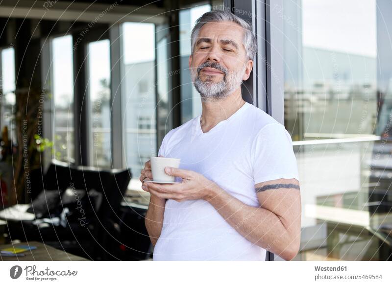 Man standing at French enjoying cup of coffee Coffee Cup Coffee Cups indulgence enjoyment savoring indulging French Door window windows pleasure smiling smile