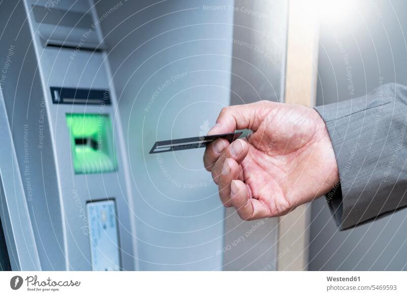 Close-up of businessman withdrawing money at an ATM business life business world business person businesspeople Business man Business men Businessmen finances