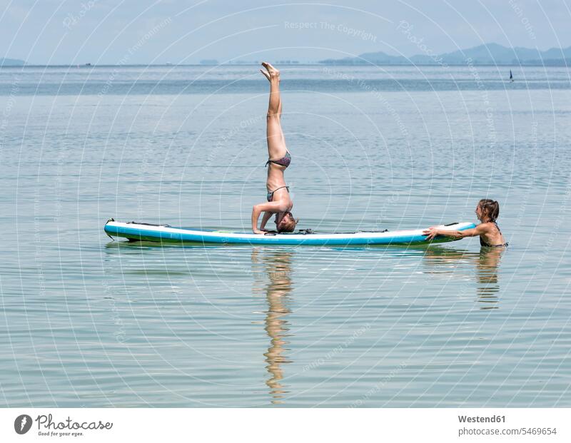 Thailand, Krabi, Lao Liang, woman doing a headstand on SUP Board in the ocean SUP-Board Standup Paddle Boards SUP-Boards SUP Boards stand up paddle board sea