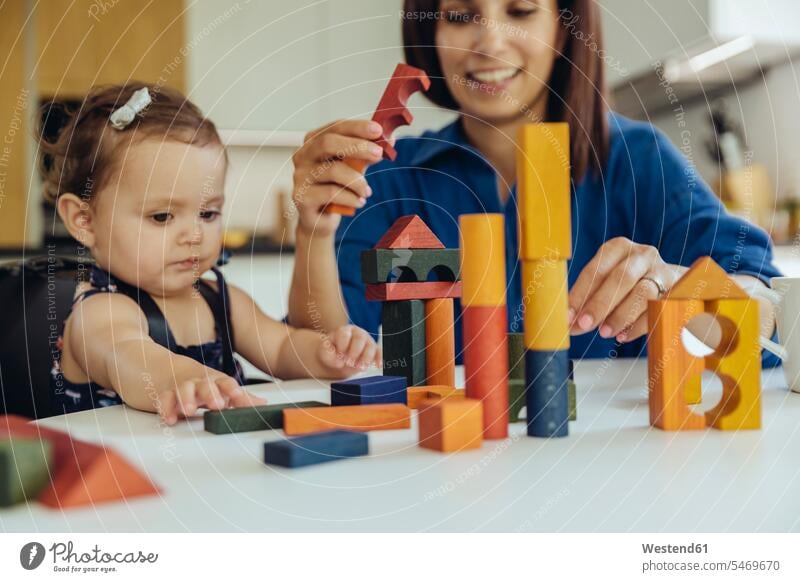 Happy mother and baby daughter playing with building blocks happiness happy infants nurselings babies mommy mothers ma mummy mama daughters people persons