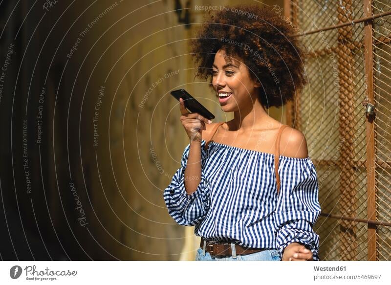 Portrait of fashionable young woman with curly hair on the phone call telephoning On The Telephone calling curls portrait portraits telephone call Phone Call
