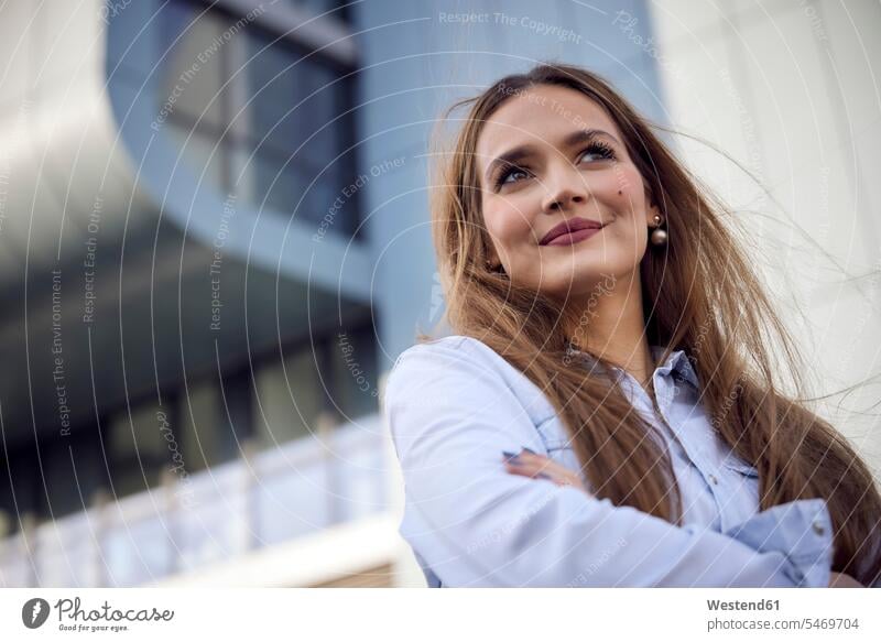 Thoughtful businesswoman looking away while standing outdoors color image colour image location shots outdoor shot outdoor shots sunset sunsets sundown