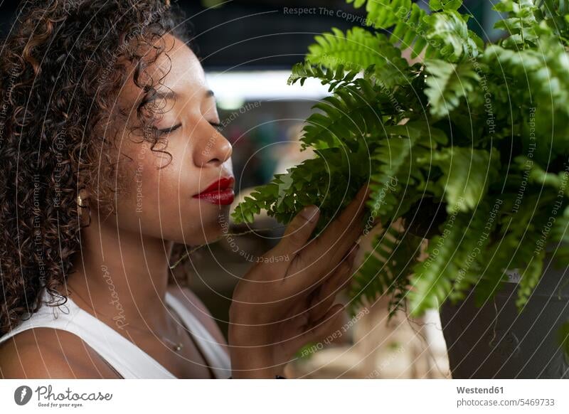 Young woman smelling fern touching love of nature ferns fern plant beautiful Red Lips mindfulness aware awareness self-care young women young woman one person 1