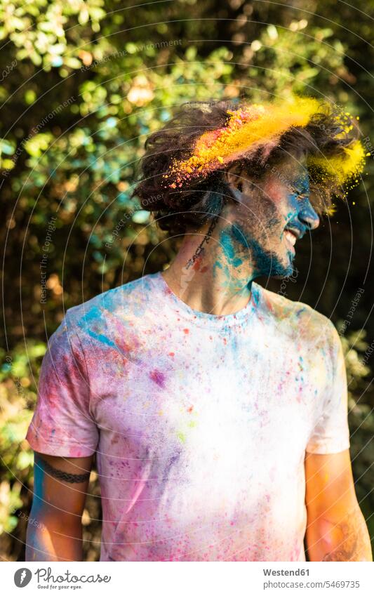 Man shaking his head, full of colorful powder paint, celebrating Holi, Festival of Colors Shaking Head Powder Paint celebration Red-Letter Day Festive Day