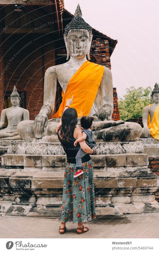 Thailand, Ayutthaya, back view of mother and little daughter visiting Wat Yai Chaya Mongkhon mommy mothers ma mummy mama daughters viewing parents family