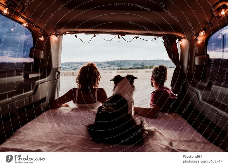 Man and woman with dog in camper trailer color image colour image Spain leisure activity leisure activities free time leisure time dogs Canine domestic dog pets