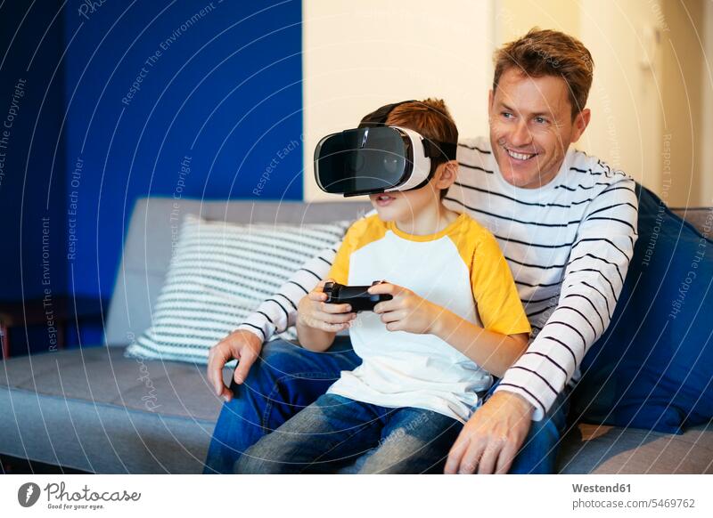 Father and Son Playing Video Games --- Image by © Royalty-…