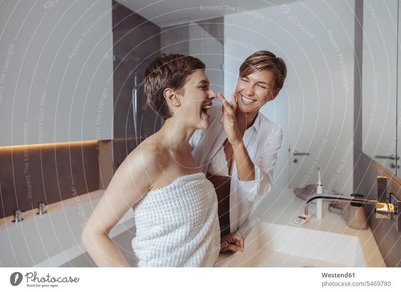 Happy lesbian couple getting ready for their day in the bathroom happiness happy get ready twosomes partnership couples Domestic Bathroom bath room people