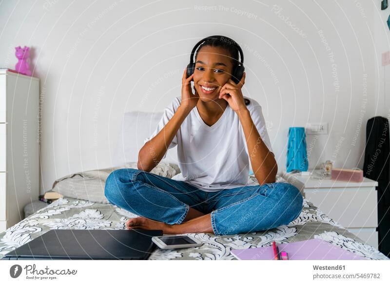 Young girl with cross legged listening to music while sitting at home color image colour image indoors indoor shot indoor shots interior interior view Interiors