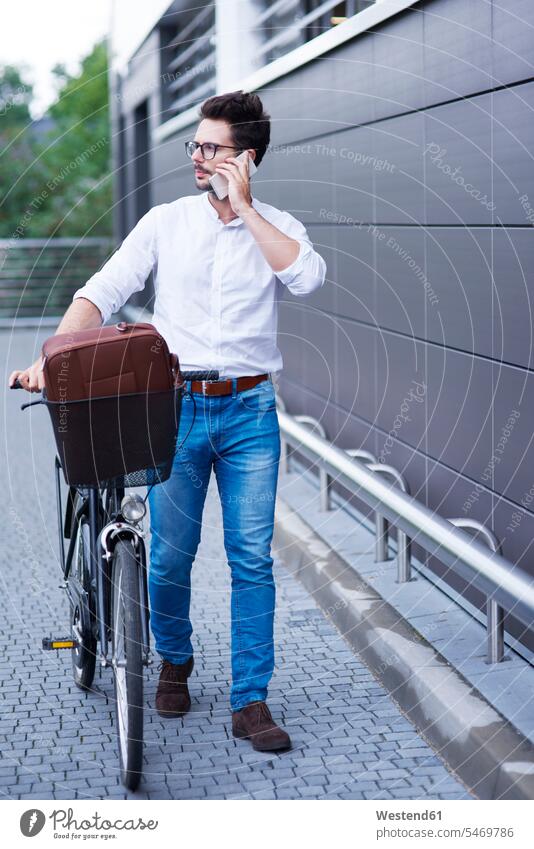 Businessman on the phone pushing his bicycle call telephoning On The Telephone calling bikes bicycles Business man Businessmen Business men telephone call