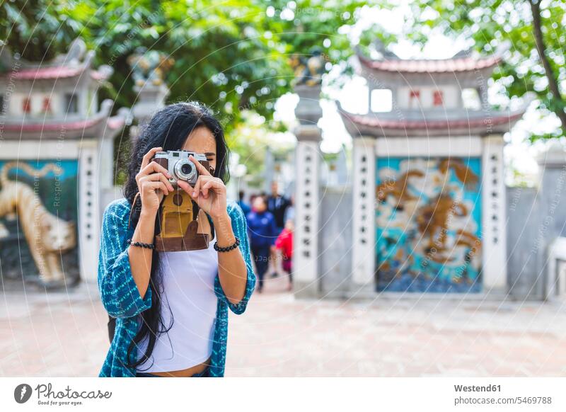 Vietnam, Hanoi, young woman taking a picture with old-fashioned camera cameras females women photographing Adults grown-ups grownups adult people persons