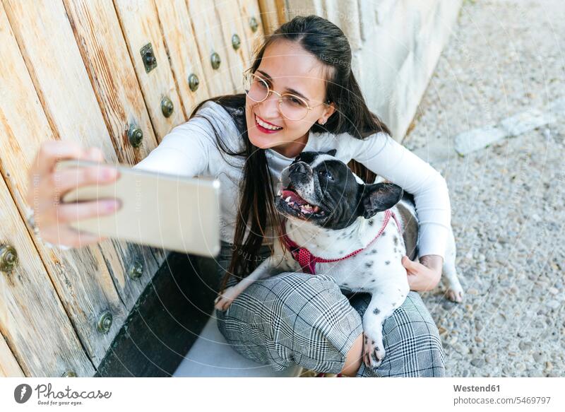 Young woman using smartphone, taking a selfie with her dog animal-loving fond of animals love of animals Selfie Selfies Smartphone iPhone Smartphones use