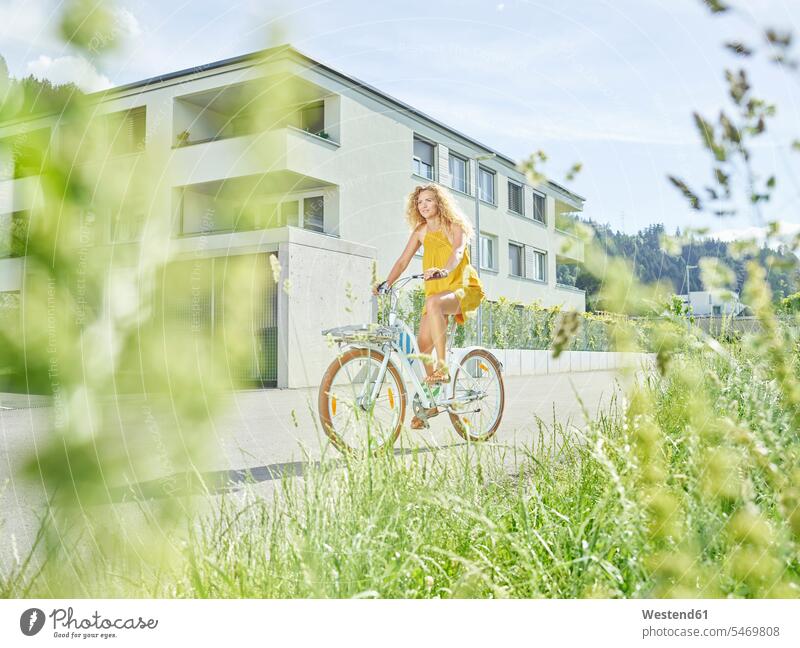 Young woman riding bicycle females women riding bike bike riding cycling bicycling pedaling bikes bicycles Adults grown-ups grownups adult people persons