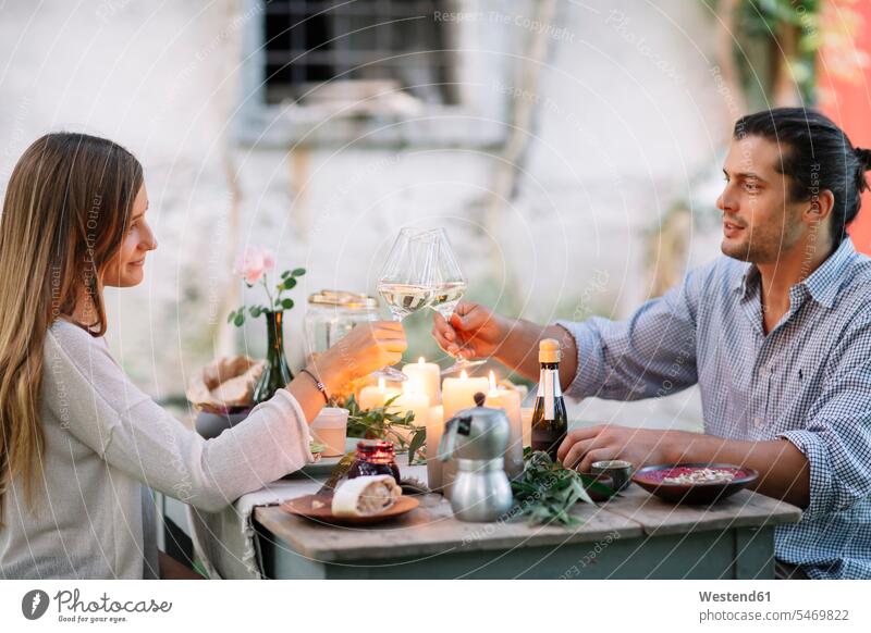 Couple having a romantic candlelight meal clinking wine glasses Meals Wine Glass Wine Glasses Wineglass Wineglasses toasting cheers candle light couple twosomes
