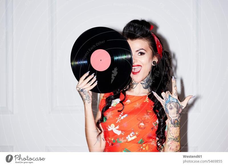 Portrait of tattooed woman with record showing Rock And Roll Sign Rock and Roll rock 'n' roll females women vinyl record records tattoos portrait portraits
