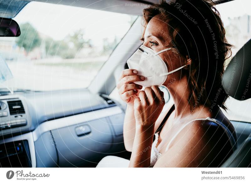 Woman wearing protective face mask in car during COVID-19 color image colour image Vehicle Interior day daylight shot daylight shots day shots daytime