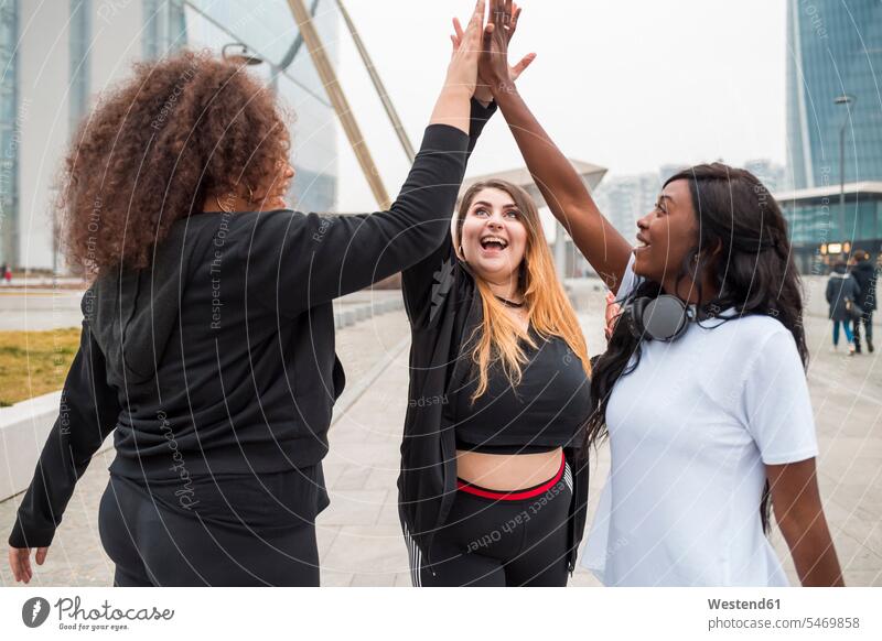 Three sportive young women high fiving in the city human human being human beings humans person persons caucasian appearance caucasian ethnicity european