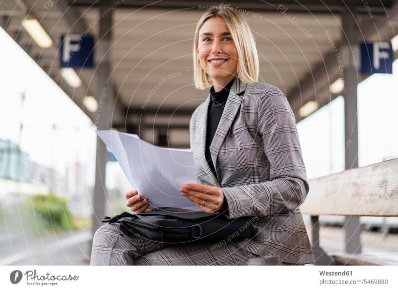 Smiling young businesswoman with papers at the train station Occupation Work job jobs profession professional occupation business life business world