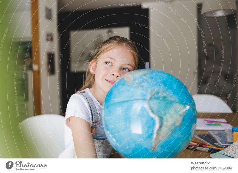 Portrait of confident girl with globe at home looking at distance human human being human beings humans person persons caucasian appearance caucasian ethnicity