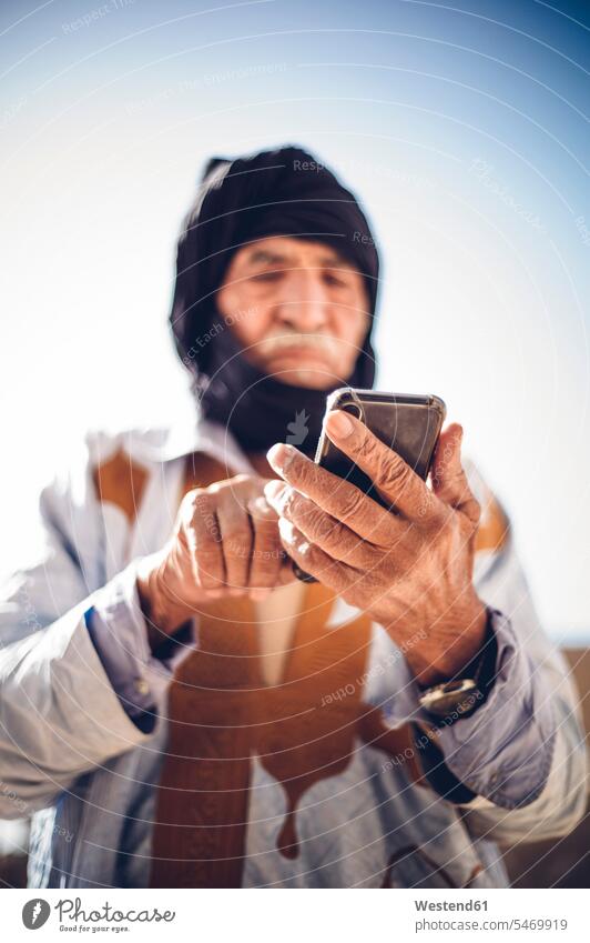 Senior man using cell phone in Smara refugee camp, Tindouf, Algeria human human being human beings humans person persons North African 1 one person only