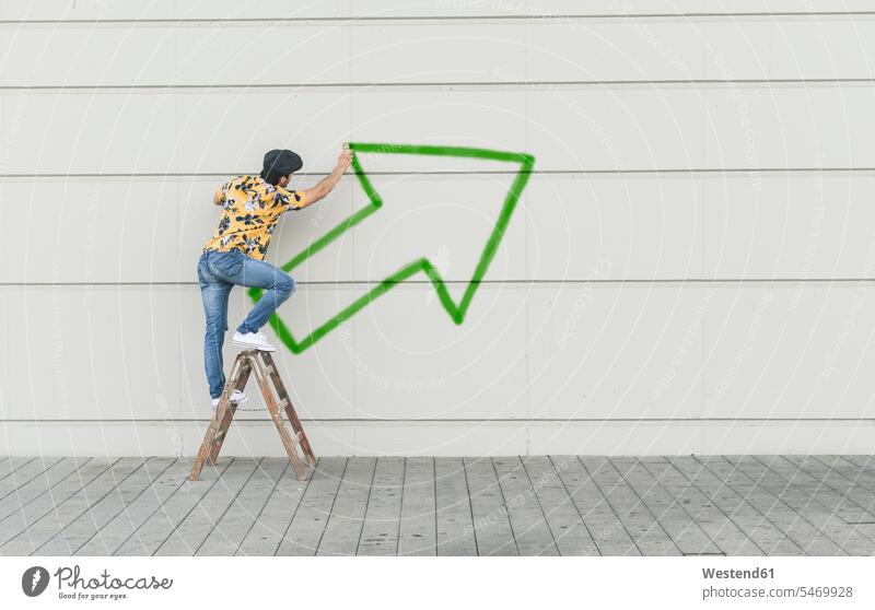 Digital composite of young man drawing an arrow at a wall human human being human beings humans person persons caucasian appearance caucasian ethnicity european
