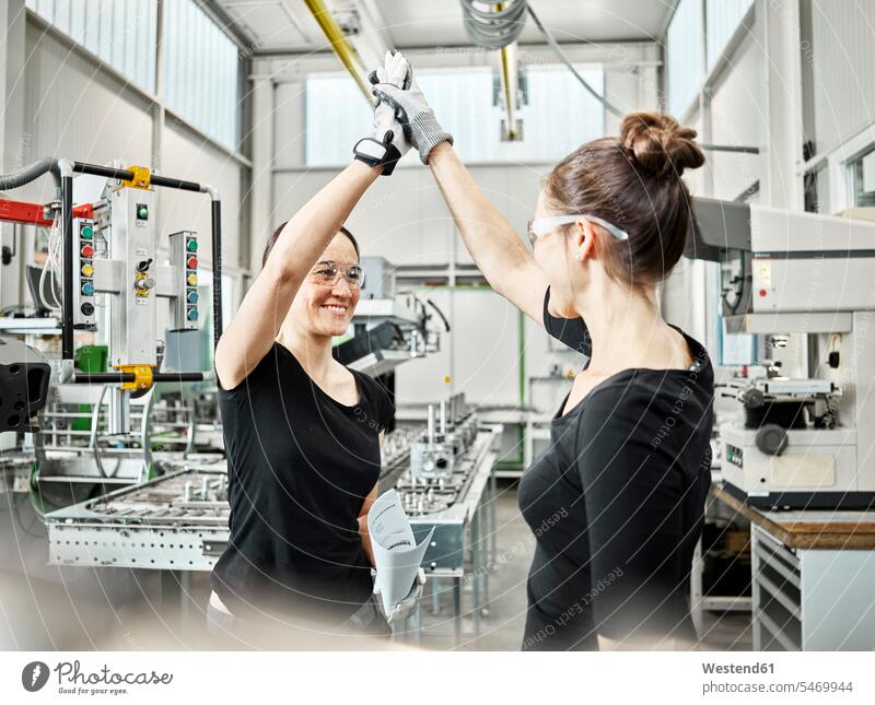 Two women at work, high five Austria worker female workers metalworking metal fabrication metal working metal processing Competence Skill metal construction