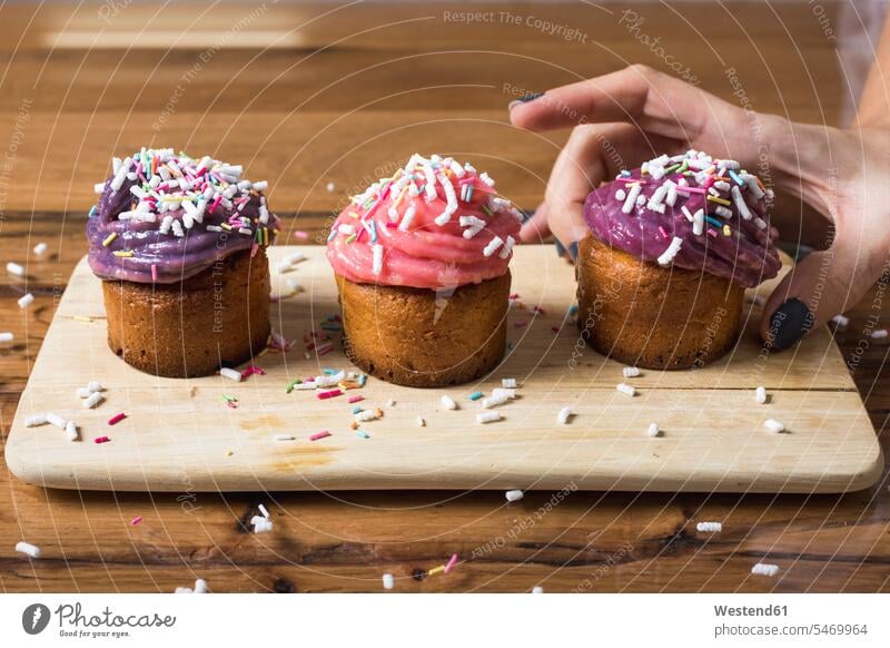 Woman taking muffin cup cake Cup cakes Cupcakes cupcake topping garnished Toppings Topped Pastry Pastries Sweet Food sweet foods food and drink Nutrition