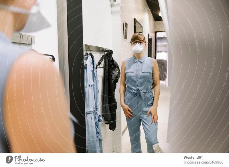 Woman with face mask trying on clothes in a fashion store Mirror - Object mirrors Eye Glasses Eyeglasses specs spectacles dress buy shop change changing health
