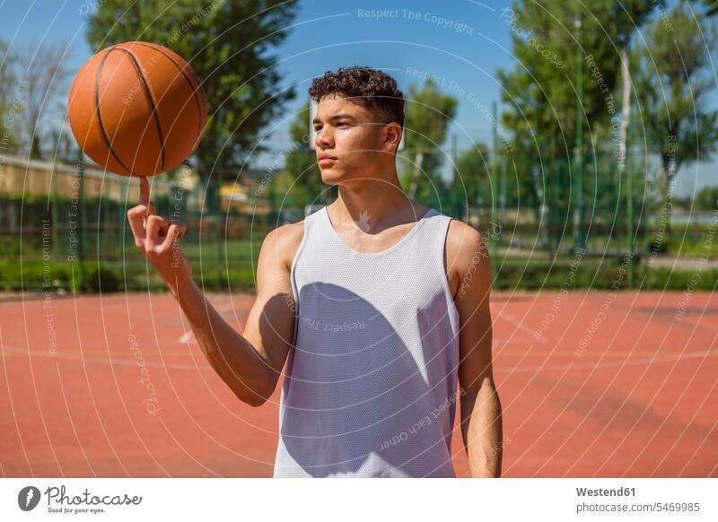 Young man playing with basketball Mixed Race Person mixed-race Person mixed race ethnicity one young man only 1 only one young man one young  man basketballs