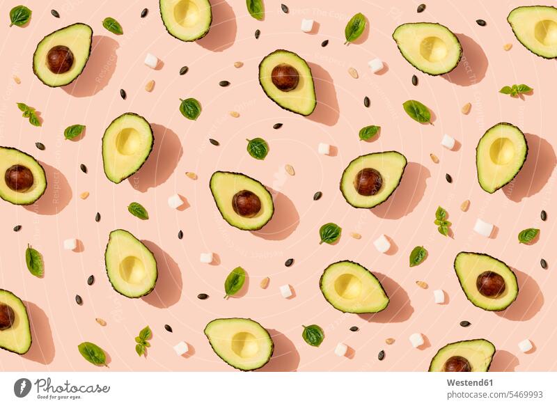 Pattern of halved avocados, pumpkin seeds, basil and pieces of cheese studio shot studio photograph studio photographs studio shots indoors indoor shot