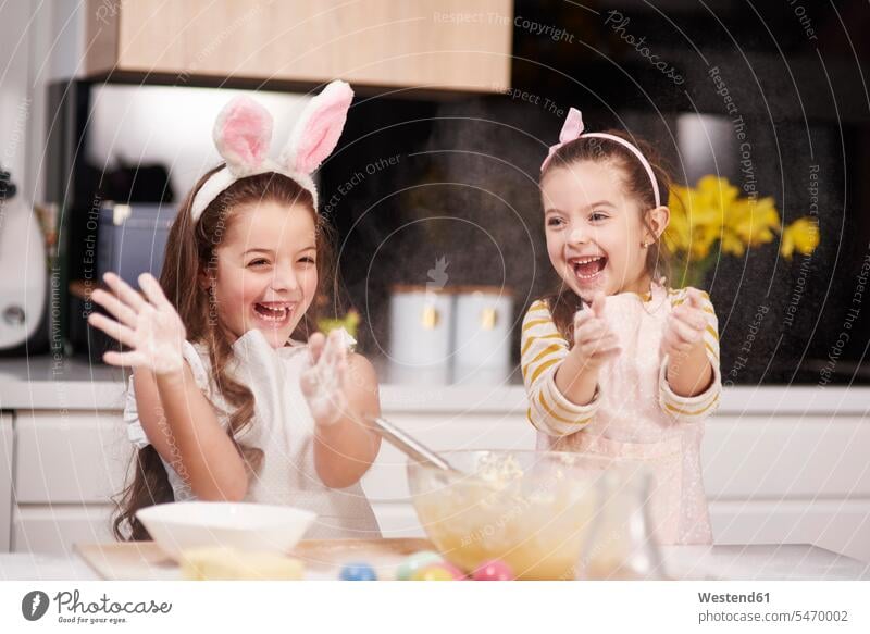 Two playful sisters having fun baking Easter cookies in kitchen together Fun funny bake Biscuit Cookie Cooky Cookies Biscuits girl females girls celebration