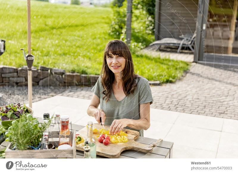 Portrait of smiling woman preparing a salad on garden table human human being human beings humans person persons caucasian appearance caucasian ethnicity