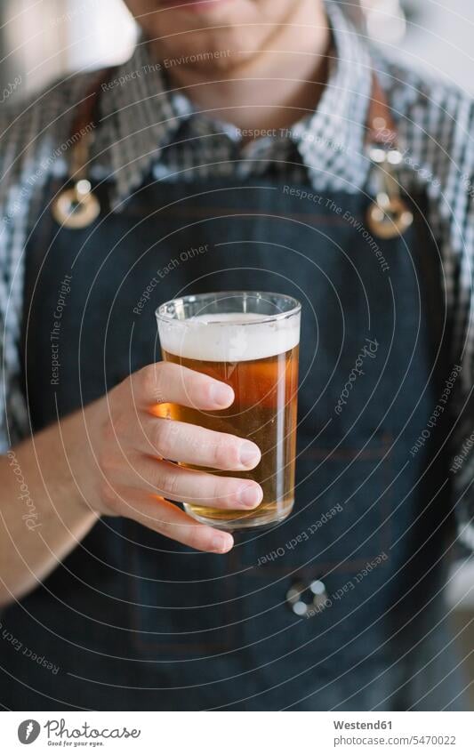 Close-up of young man holding beer glass at a brewery human human being human beings humans person persons caucasian appearance caucasian ethnicity european 1