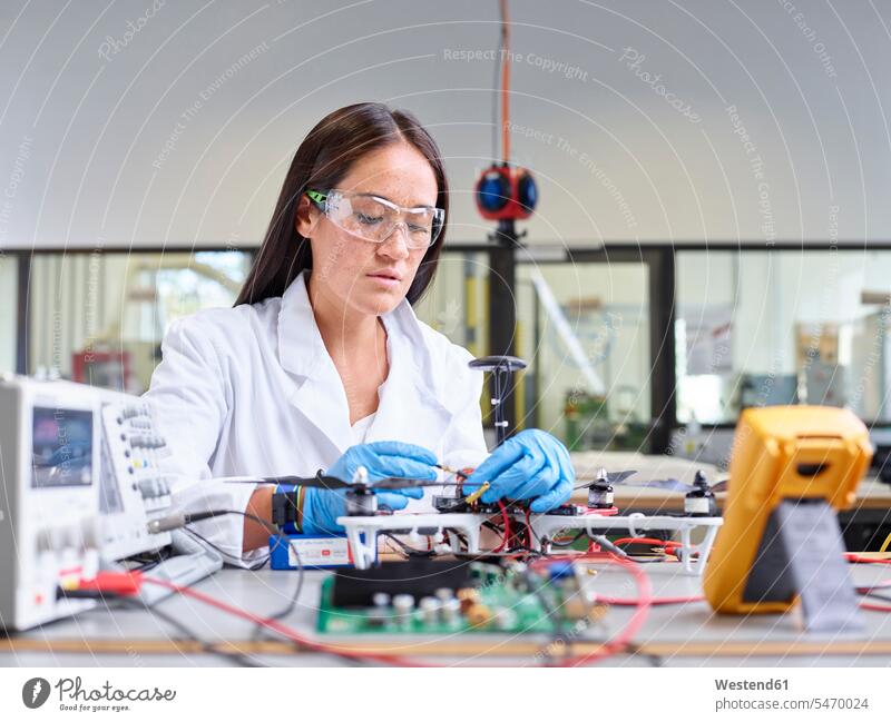 Female technician working in research laboratory, connecting plug of drone At Work drones occupation profession professional occupation jobs woman females women