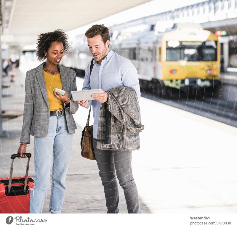 Young businessman and businesswoman using tablet together at the train station Occupation Work job jobs profession professional occupation business life