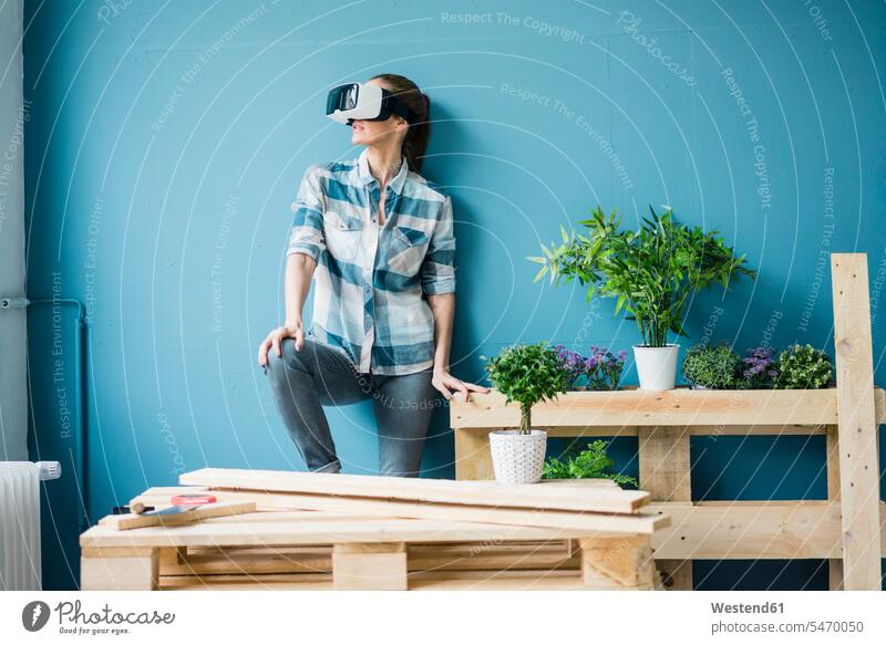 Woman using VR glasses, renovating her new home renovation renovate refurbish refurbishing Renovations redecorating Virtual Reality Glasses