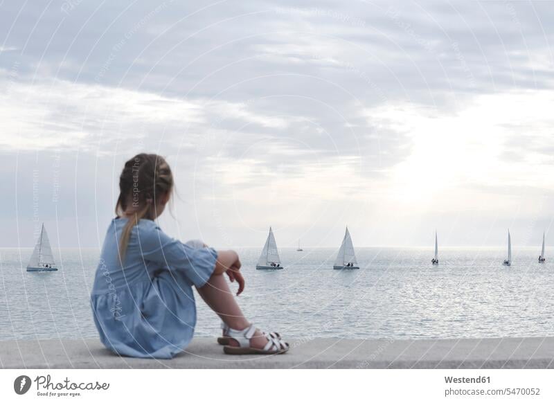 Lttle girl looking at the sea with boats Nautical Vessel nautical vessels water vehicle water vehicles watercraft Sail Boat sailboat Sailboats sailing boats