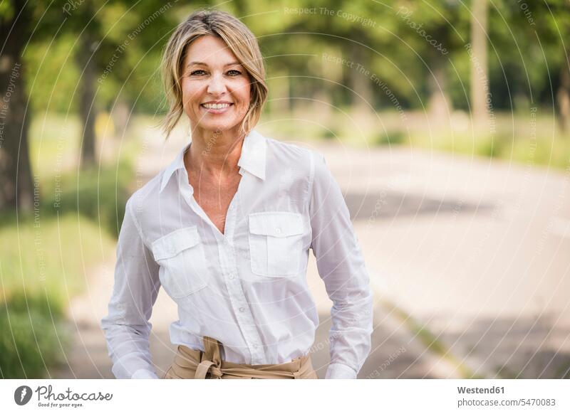 Confident mature businesswoman smiling while standing outdoors color image colour image location shots outdoor shot outdoor shots day daylight shot