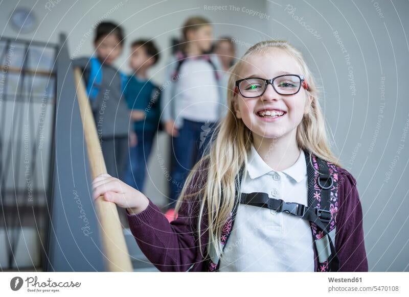 Portrait of happy schoolgirl with classmates on staircase leaving school schools happiness leave female pupils School Girl schoolgirls School Girls staircases