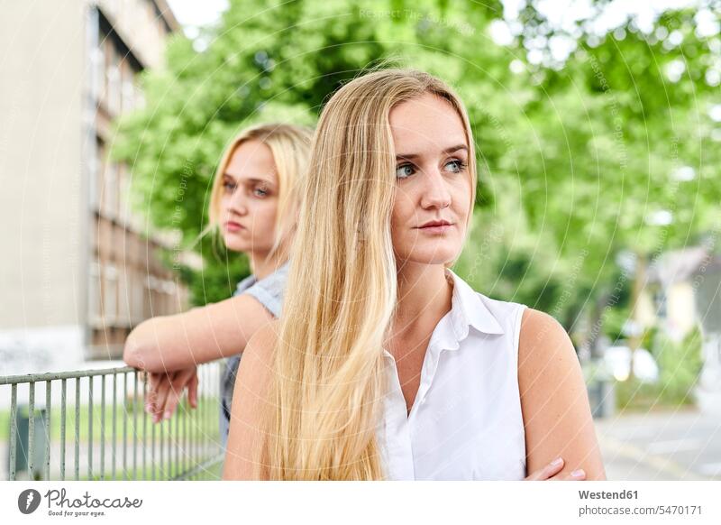 Two discontented young women outdoors woman females Discontent unsatisfied dissatisfaction female friends city town cities towns Adults grown-ups grownups adult