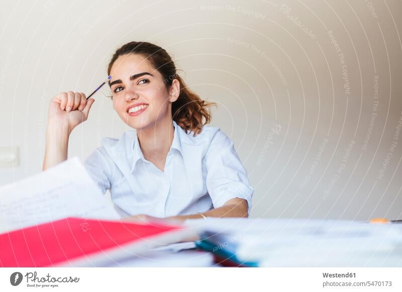 Smiling female student learning at desk at home human human being human beings humans person persons caucasian appearance caucasian ethnicity european 1