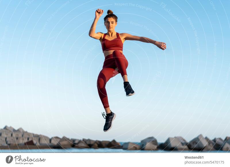 Sportive young woman during workout, jumping Leaping mid-air midair mid air working out work out athlete sportswoman athletes female athlete sportswomen