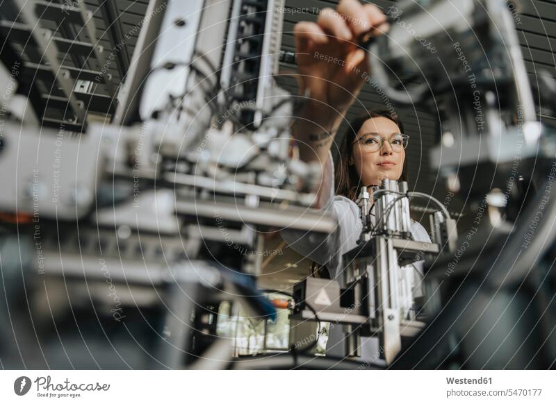 Close-up of young woman examining machinery in laboratory color image colour image indoors indoor shot indoor shots interior interior view Interiors scientist