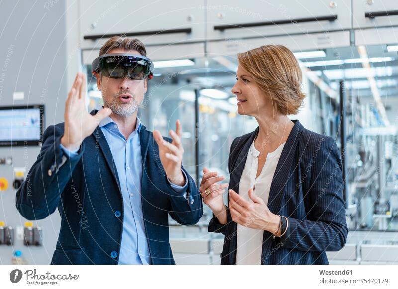 Businessman with AR glasses and businesswoman in a modern factory human human being human beings humans person persons caucasian appearance caucasian ethnicity