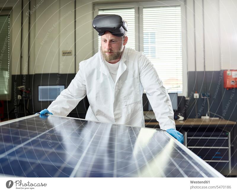 Technician with VR glasses controlling solar panel in lab human human being human beings humans person persons caucasian appearance caucasian ethnicity european