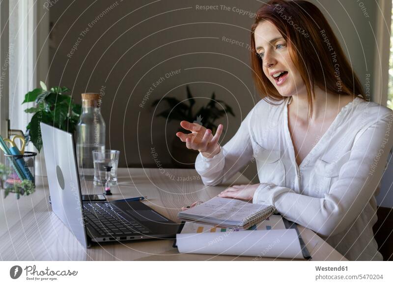 Doctor discussing on video call through laptop while sitting at home color image colour image indoors indoor shot indoor shots interior interior view Interiors