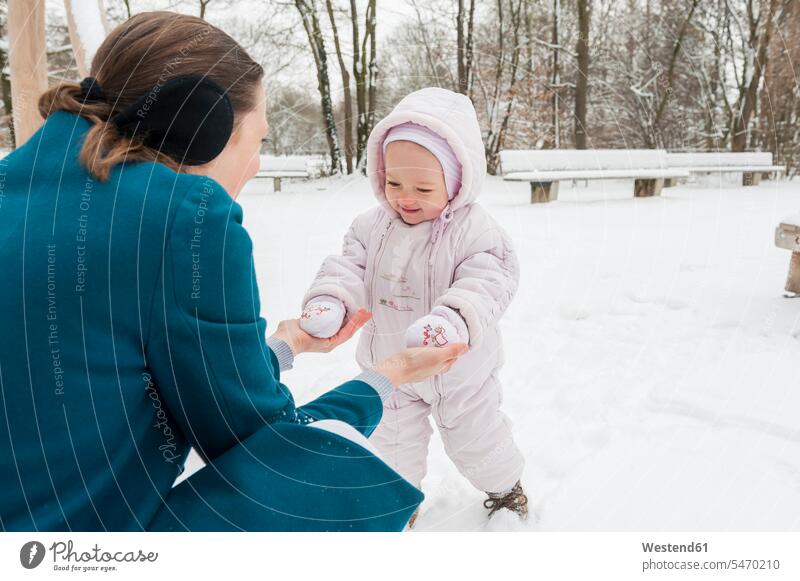 Mother and baby girl in snow baby girls female mother mommy mothers mummy mama infants nurselings babies people persons human being humans human beings weather