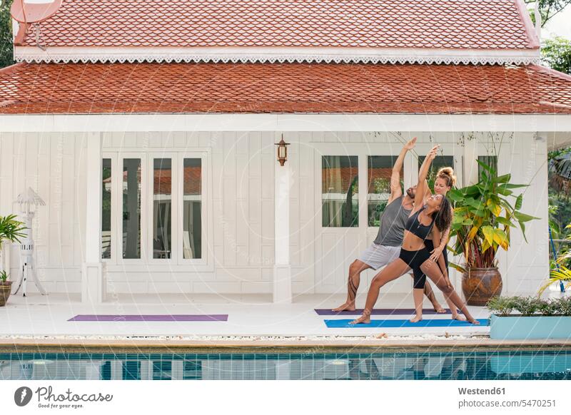 Yoga instructor teaching woman correct yoga pose on terrace Yoga Pose Asana Yoga Posture Yoga Position correcting corrected swimming pool pools swimming pools