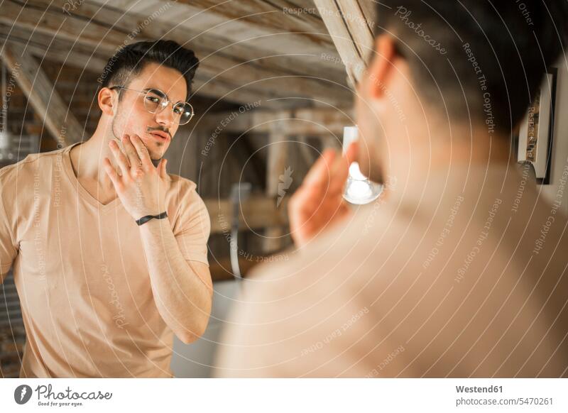 Young man looking in bathroom mirror Domestic Bathroom bath room mirrors watching men males rooms domestic room domestic rooms view seeing viewing Adults