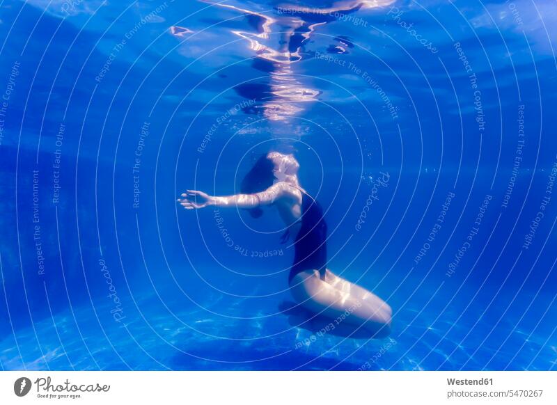 Young woman underwater in a swimming pool diving dive females women submerged Under Water underwater shot underwater shots pools swimming pools Adults grown-ups